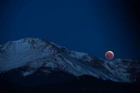 COLORADO SPRINGS, CO - APRIL 04: Sky-watchers got a glimpse of the Blood Moon in the shortest eclipse of the century as it sets behind Pikes Peak April 4, 2015 in Colorado Springs. The top edge of the eclipsed moon should appear much brighter than the rest of the orb.(Photo By John Leyba/The Denver Post via Getty Images)